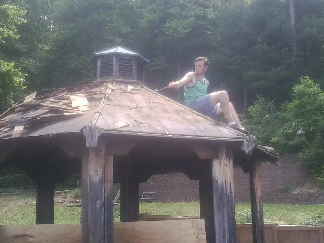 Tearing the old roof off a wooden gazebo before new shakes in Junction City